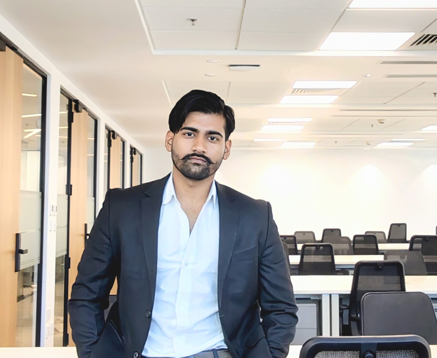 Portrait of Hritik Singh Rajput, SEO specialist and web developer, in a navy blazer at his office workspace